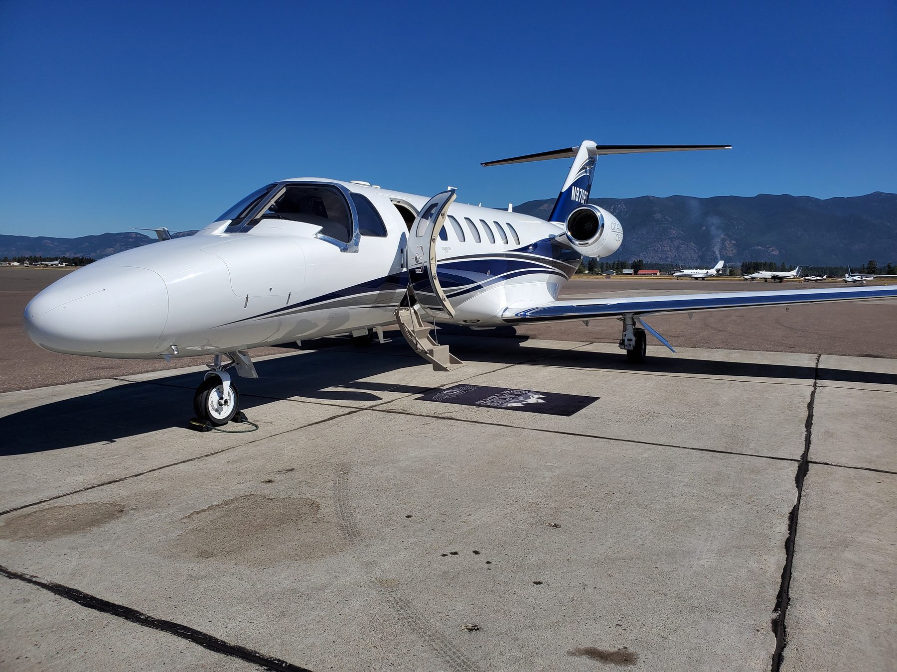 Citation CJ3+ with airstair open on a mountain-airport ramp under clear skies