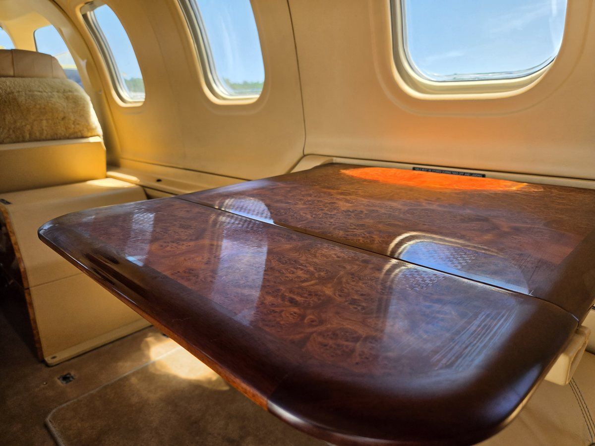 Polished burl wood executive table deployed in the cabin of TBM 700C2 N6272B